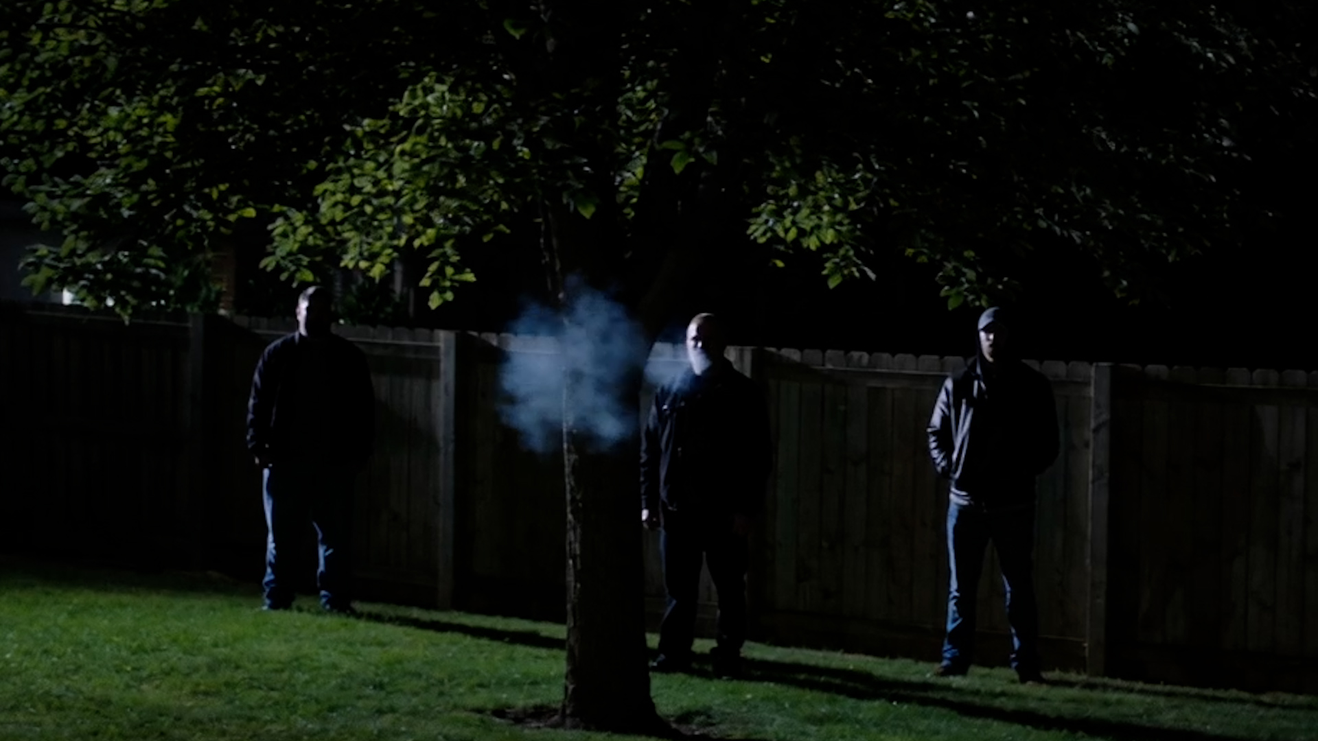 A backyard at night with a security light