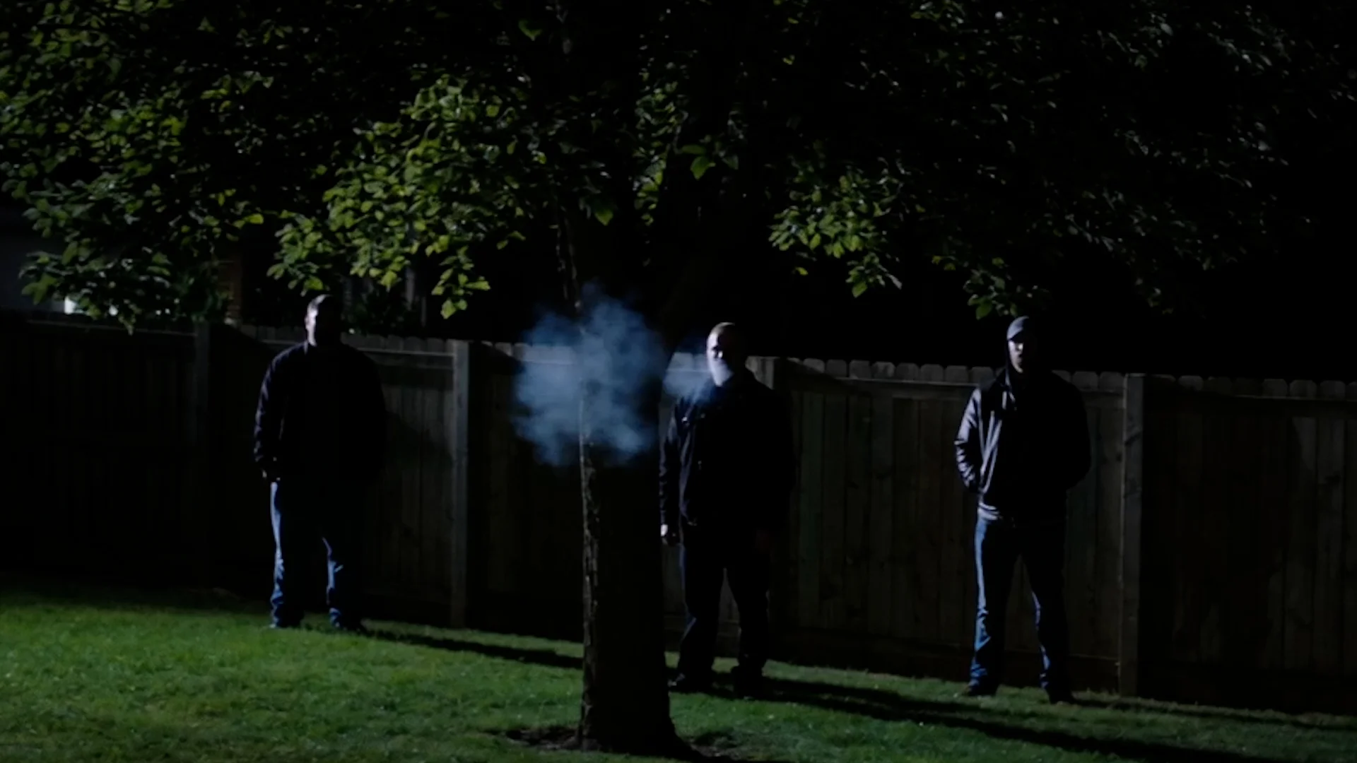 A backyard at night with a security light
