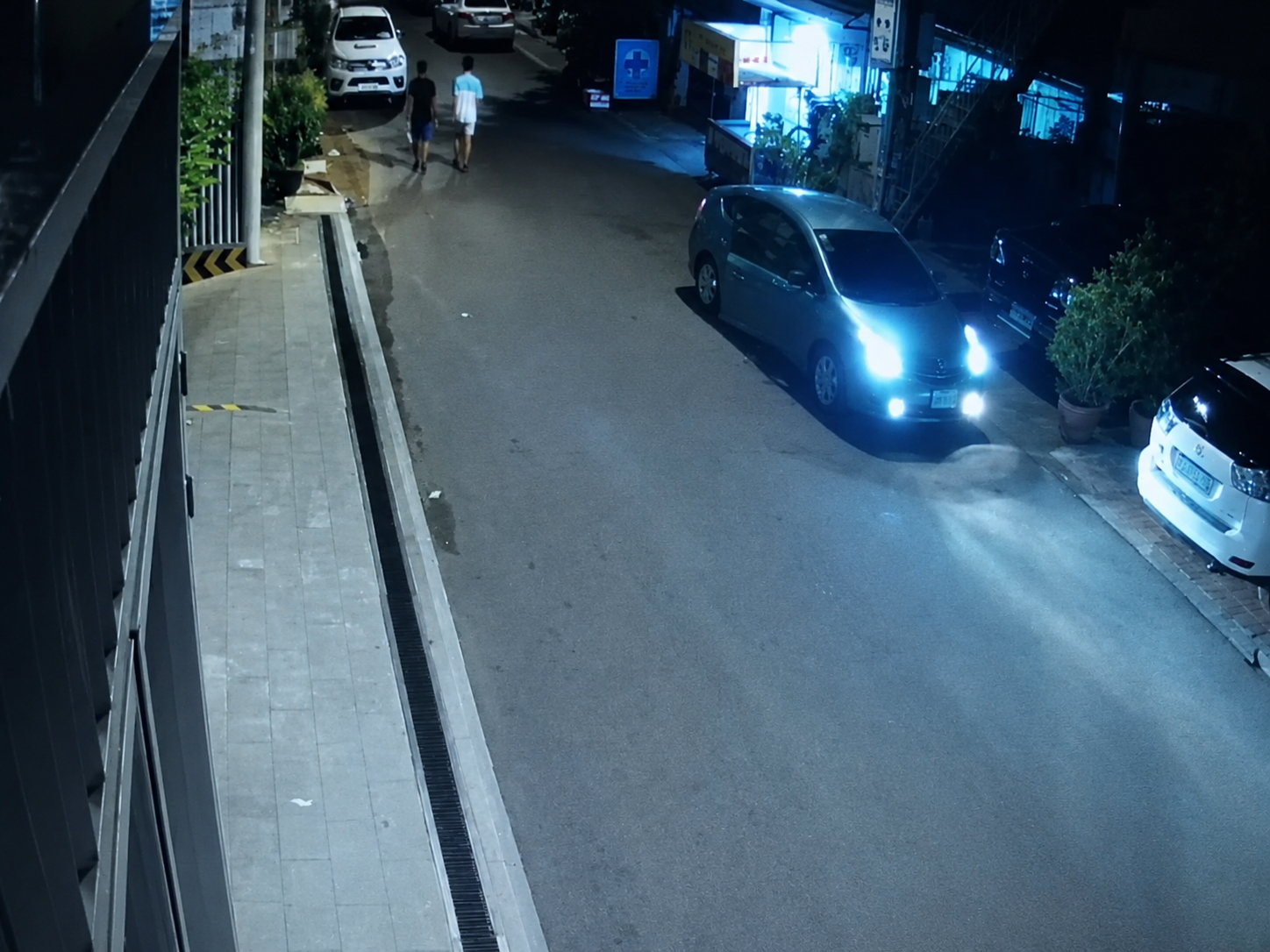 A blue sedan parked at night