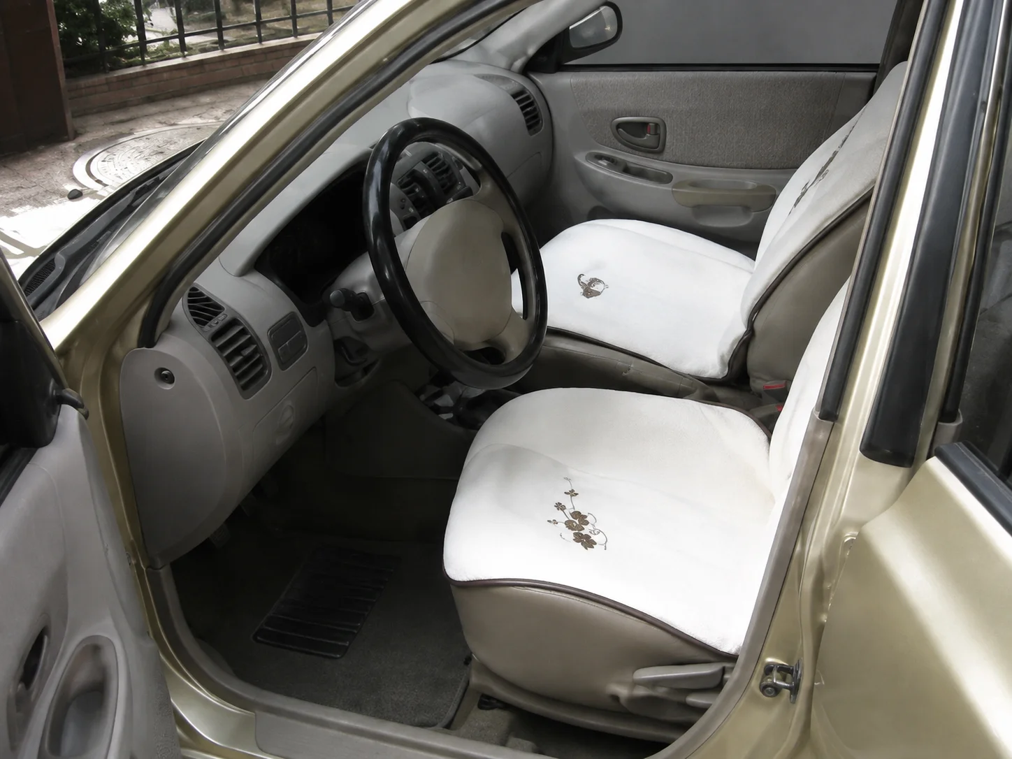The front seats of a car fitted with white seat covers