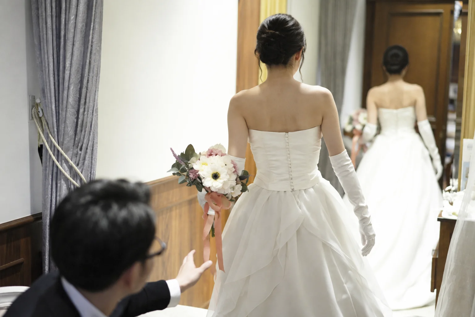 A bride in a wedding dress being helped by a man