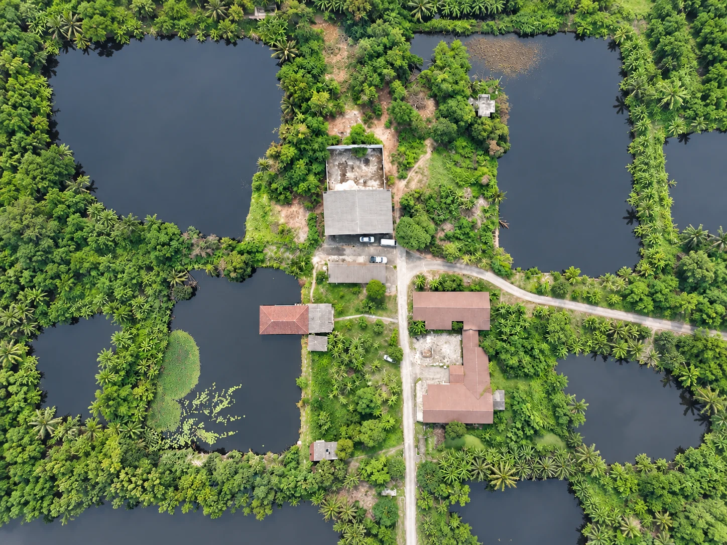 An aerial view of a mansion estate surrounded by large ponds