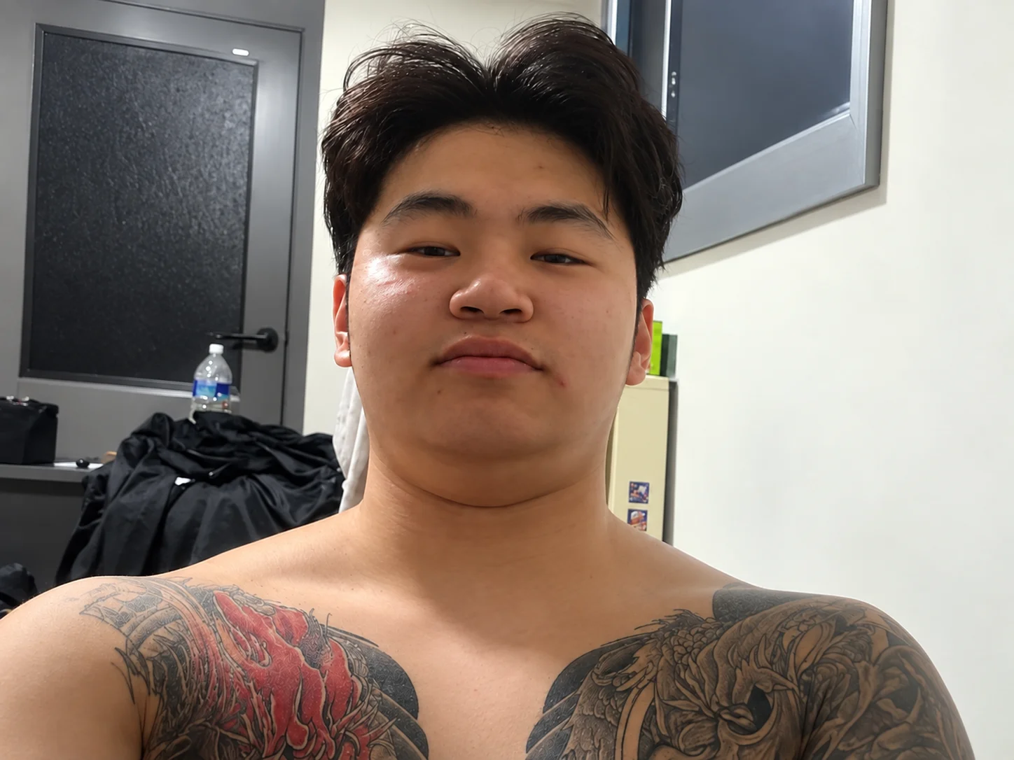 Jae-hwan Jeong taking a shirtless selfie showing his tattoos