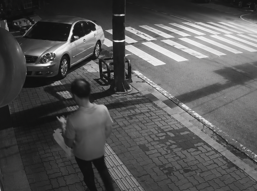 Security camera footage capturing the masked suspect near the parking lot